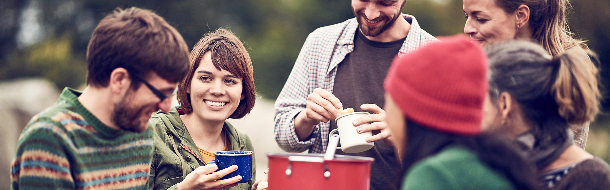A group of adult friends having picknick in the fall.